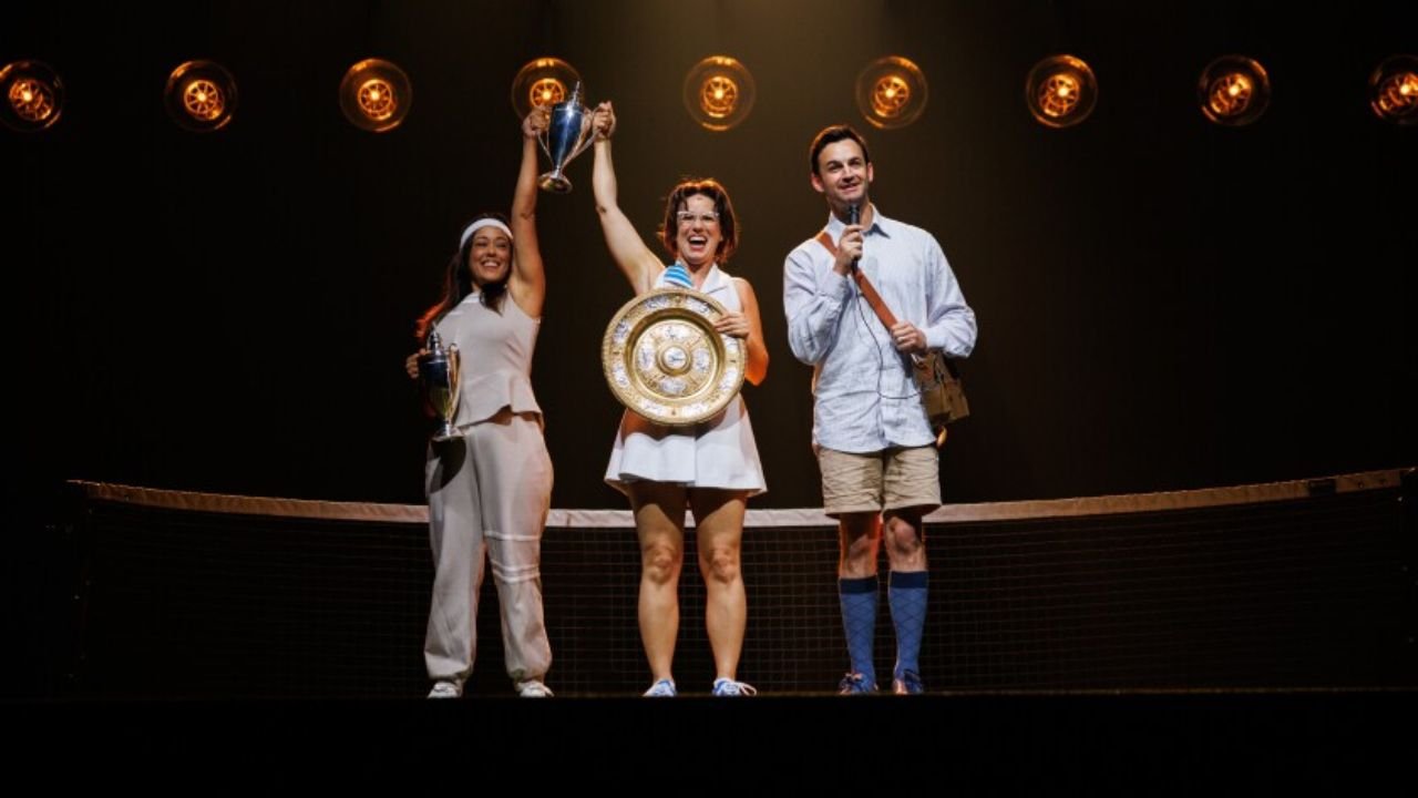Here’s your review article draft for *Billie Jean* at Chicago Shakespeare Theater, based on the original piece from Chicago Culture Authority: --- # Billie Jean at Chicago Shakes Serves Up an Uplifting, Complex Portrait of a Sports Icon **Meta Title:** Billie Jean King Shines in Chicago Shakespeare Theater’s Uplifting New Play **Meta Description:** Lauren Gunderson’s *Billie Jean* celebrates the legacy of tennis legend Billie Jean King in a moving, inspirational production now playing at Chicago Shakespeare Theater through August 10. **Author:** Leo Hart **Category:** Event Reviews --- **CHICAGO** – In *Billie Jean*, now on stage at Chicago Shakespeare Theater through August 10, audiences are treated to a stirring, inspiring look at the life of tennis icon Billie Jean King — a woman who not only dominated the court but also shattered societal barriers with relentless determination. **An Icon Brought to Life** Written by Lauren Gunderson, the play is an uplifting mix of sports biography and civil rights drama. Think *42* or *A League of Their Own*, but with sharper edges — a celebration of Billie Jean King’s powerful influence in both athletics and equality. Chilina Kennedy delivers a knockout performance as King, portraying her not just as an athlete, but as a trailblazer who redefined what it means to win. From battling gender discrimination in tennis to founding the Women’s Tennis Association, her victories off the court are shown to be as vital as her 39 Grand Slam titles. **A Personal Story Told with Humanity** The play digs into King’s personal life with surprising intimacy. One of the most emotional arcs follows her relationship with her husband Larry King, played with nuance by Dan Amboyer. Their dynamic reveals deep love and mutual respect, but also the complexities of personal identity and the toll of public expectations. The show doesn’t shy away from Billie Jean’s journey of coming out, her advocacy for LGBTQ+ rights, and her support for fellow trailblazers like Renée Richards — a powerful nod to how her fight extended far beyond tennis. **Moments of Humor and Humanity** While the production has a few repetitive beats — yes, the metaphor of tennis scoring with “love” gets heavily used — it ultimately delivers a deeply satisfying and emotionally resonant experience. The script weaves between humor, struggle, and triumph without losing its grip on the real-life stakes. **Final Verdict** This isn’t just a sports play. It’s a reminder of what leadership looks like, and how courage is often forged under pressure. Whether you're a fan of tennis, theater, or social justice, *Billie Jean* offers something worth standing and applauding for. The show runs through **August 10** at Chicago Shakespeare Theater on Navy Pier. For full details and ticket info, visit the [official Chicago Shakes website](https://www.chicagoshakes.com/productions/2526-billie-jean/). --- **🎾 What Do You Think?** Did Billie Jean King’s story move you? What moment hit you hardest — her court battles or personal ones? Share your thoughts in the comments at **ChicagoMusicGuide.com**. --- Let me know if you’d like a version of this review embedded with social media reactions or critic round-up links!