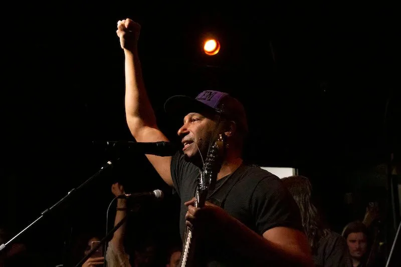 Tom Morello performing with a guitar on stage during a concert