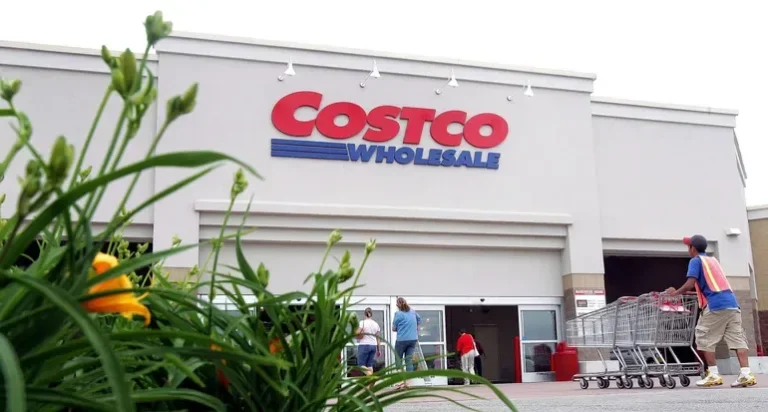 A Costco warehouse and gas station with shoppers entering the store