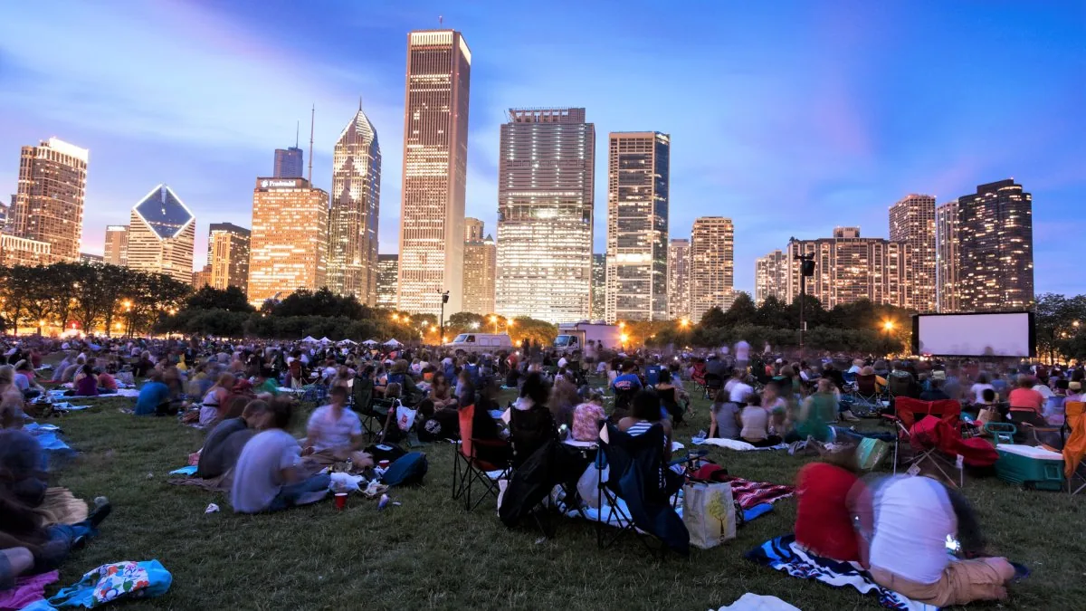 Crowds gather at a Chicago summer festival with food booths, stages and city skyline views