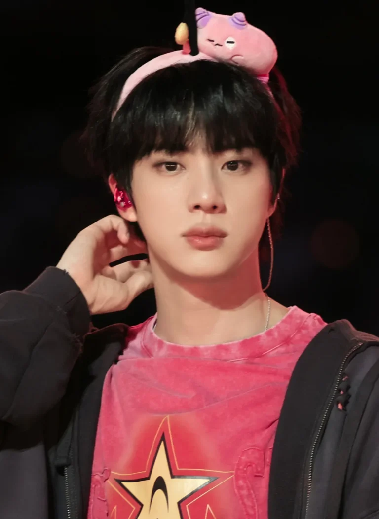 BTS member Jin at Soldier Field in Chicago, with fans reacting to a pink character hairband