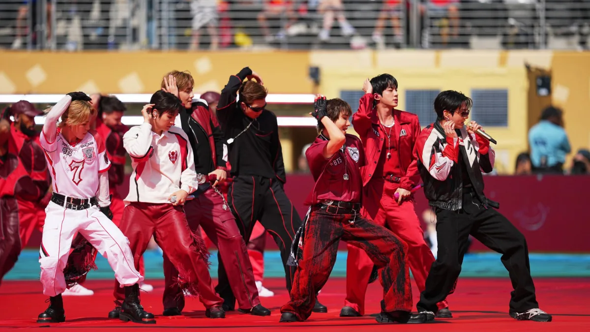 BTS members with personalized NFL-style footballs marking their Chicago Soldier Field concerts