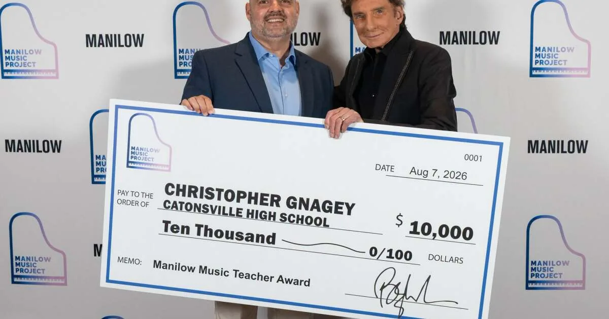 Barry Manilow presenting a $10,000 music education award at CFG Bank Arena