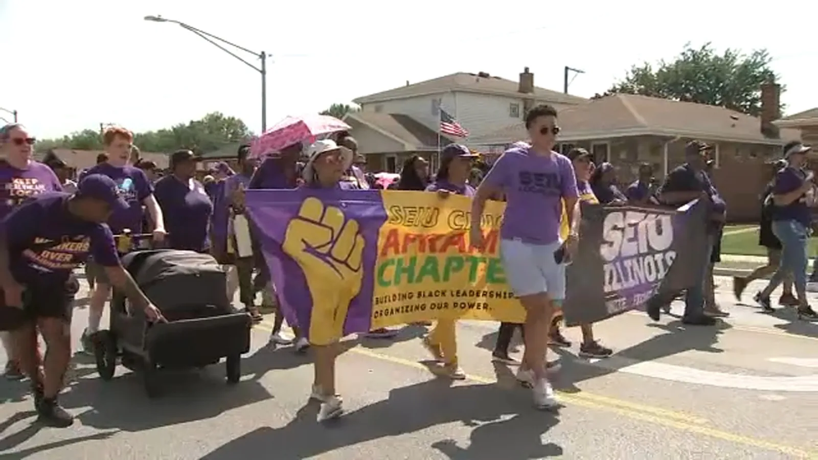 Union members march with colorful floats along Ewing Avenue during Chicago's Labor Day Parade