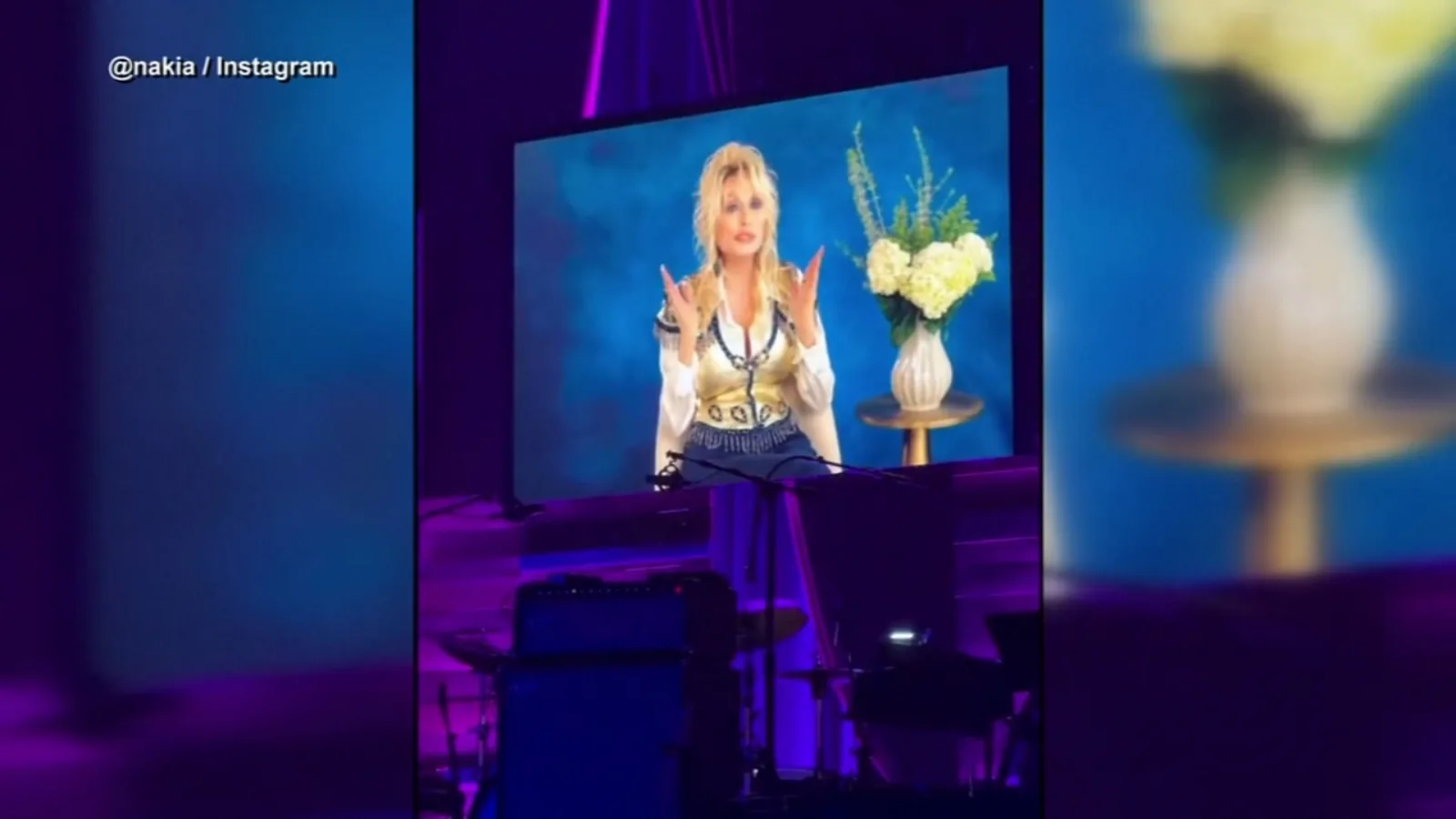 Dolly Parton on stage in a tribute setting after receiving a posthumous Americana Lifetime Achievement Award