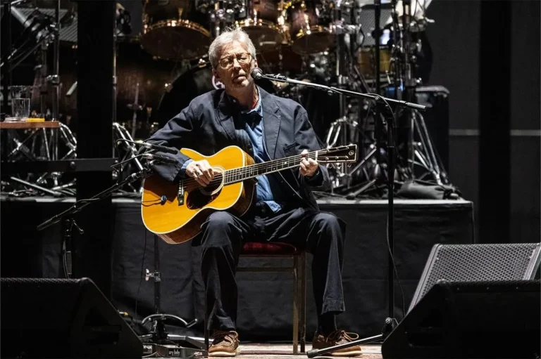 Eric Clapton performing with his band onstage during a concert