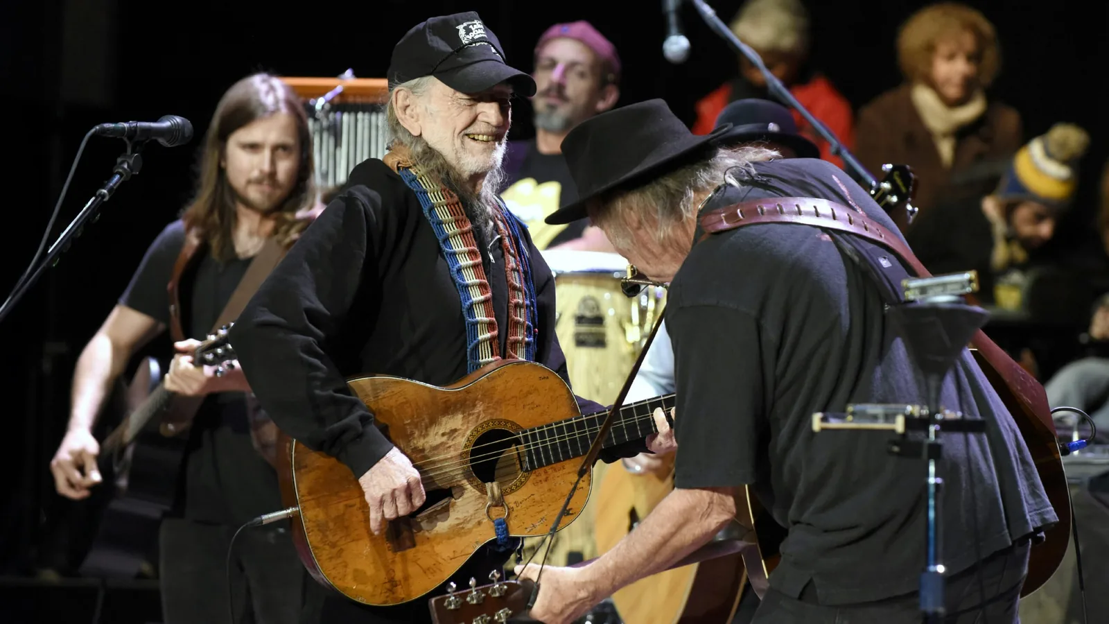 Willie Nelson and Neil Young performing together at a benefit concert