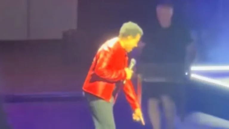Lionel Richie performing onstage before needing a chair during a St. Louis show