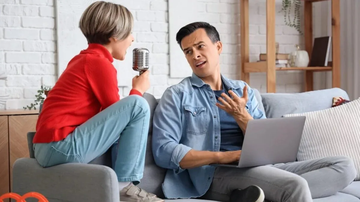 A parent and teenager discussing college choices at a kitchen table