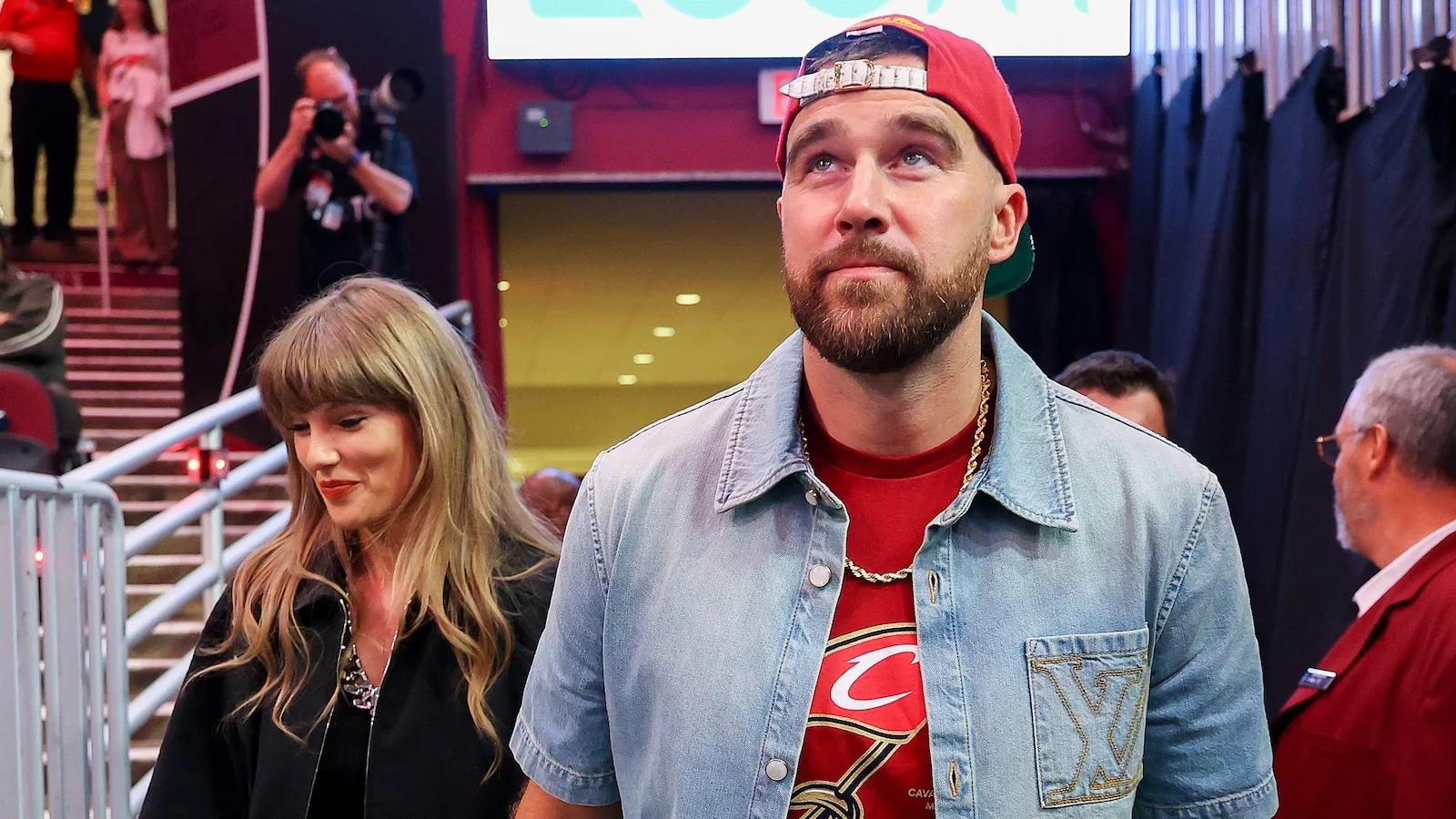 Taylor Swift and Travis Kelce smiling together at a public event