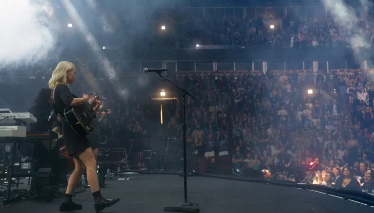 Fans at a Chicago concert holding locked phone pouches during a phone-free performance